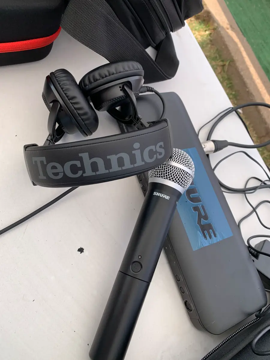 Technics headphones, Shure microphone, tablet, cases, and cables on a white surface