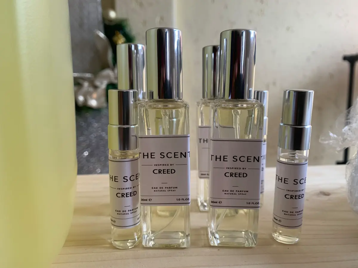 Several THE SCENT perfume bottles including Creed inspired by Eau de Parfum